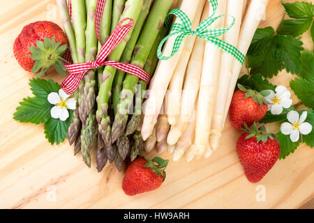 Ansicht von oben Spargel. Frischem grünem und weißem Spargel mit Erdbeeren-Bauernhaus-Stil Stockfoto