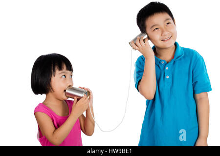 Asiatische chinesische Kid spielen mit Tin Can Telefon isoliert auf weißem Hintergrund Stockfoto