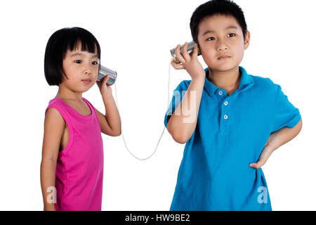 Asiatische chinesische Kid spielen mit Tin Can Telefon isoliert auf weißem Hintergrund Stockfoto