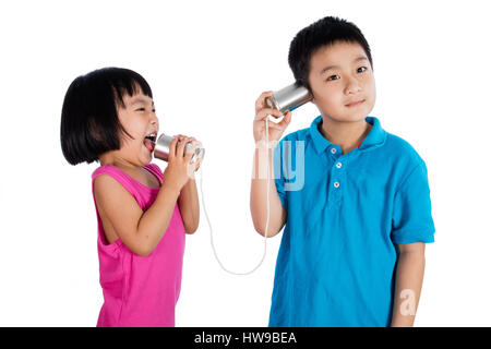 Asiatische chinesische Kid spielen mit Tin Can Telefon isoliert auf weißem Hintergrund Stockfoto