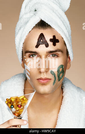 Gut aussehender Mann, Spa-Behandlungen erhalten. Foto von gepflegten Mann mit verschiedenen Gesichtsmasken. Schönheit & Skin care Konzept Stockfoto