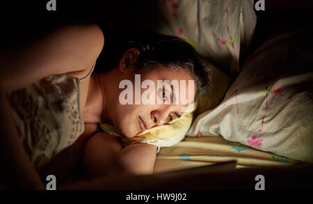 Frau mit Tablet im Bett Closeup. Gesicht des Mädchens im Hinblick auf digital-Tablette vor dem schlafen gehen Stockfoto