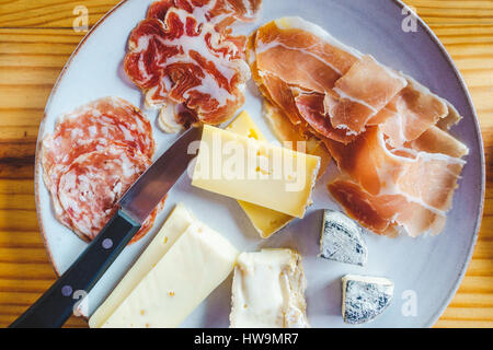 Platte mit einer Vielzahl von italienischen Käse und Wurstwaren, auf einem Holztisch Stockfoto