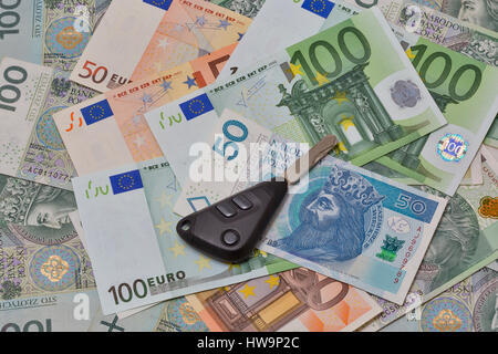 Autoschlüssel auf polnischen Zloty und Euro-Banknoten Hintergrund closeup Stockfoto