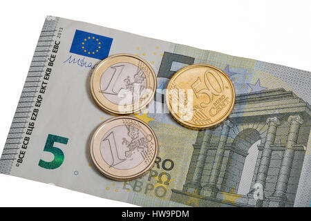 5 Euro-Banknote mit einem Euro und 50 Cent-Münzen isoliert auf weißem Hintergrund Makro Stockfoto