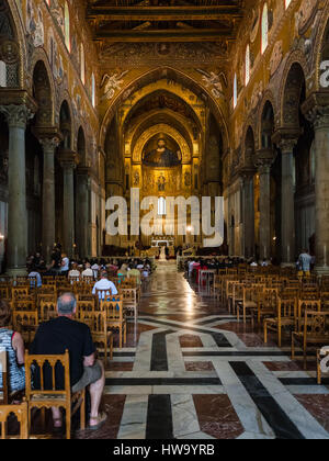 MONREALE, Italien - 25. Juni 2011: Besucher im Inneren Duomo di Monreale auf Sizilien. Die Kathedrale von Monreale ist eines der besten Beispiele von Norman Stockfoto