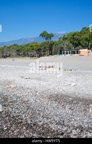 CALATABIANO, Italien - 28. Juni 2011: Menschen am Strand von San Marco am Ionischen Meer in Sizilien und Blick auf den Vulkan Ätna. Dies ist sauber, lange, ruhige, kleine pebbl Stockfoto