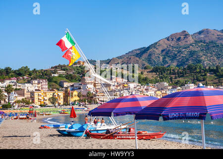 GIARDINI NAXOS, Italien - 8. Juli 2011: Flaggen über Boote und Menschen am städtischen Strand von Giardini Naxos. Naxos wurde gegründet von Thucles die chalkidischen 73 Stockfoto