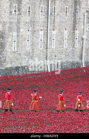 Beefeaters Yeomen des "Wachen Warder" besuchen Sie das Feld der Keramik Mohnblumen, 1. Weltkrieg Tribut, Tower of London in London am 5. August 2014. Stockfoto