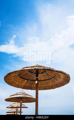 Reisen Sie nach Italien - Stroh Sonnenschirme und blauen Himmel am Strand von San Marco in Sizilien Stockfoto