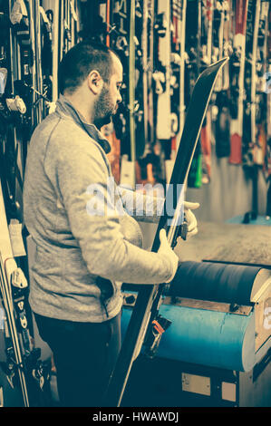 Ski-tuning und abschöpfen. Winter-Shop Arbeiter Basis Reparatur zu tun. Vermietung-Werkstatt-service Stockfoto