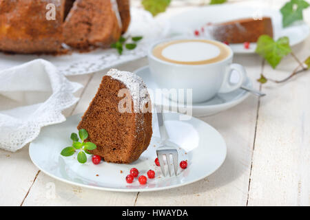 Frisch gebackener ringförmige Kuchen mit Schokolade, so genannte "Gugelhupf" in Österreich und Deutschland, mit einer Tasse Cappuccino serviert Stockfoto