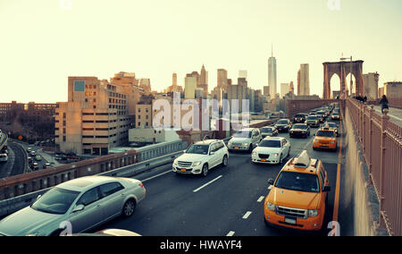 Berufsverkehr in der Innenstadt von Manhattan bei Sonnenuntergang mit Brooklyn Bridge in New York City Stockfoto