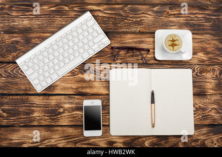 Arbeiten statt Blick von oben: Tastatur, Buch, Handy, Brille auf hölzernen Hintergrund Stockfoto