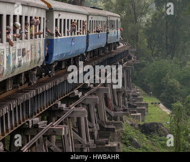 15. November 2006 - Kanchanaburi, Thailand - Passagiere achten Zug Windows, die berühmte Klippen hölzernen Trestle Tham Krasae Brücke zu fotografieren, als es Wang Pho Viadukt über den Khwae Noi Fluß überquert. Die längste Eisenbahnbrücke der hölzernen Bock in Thailand ist Teil der berüchtigten Thai-Burma Railway, auch bekannt als Death Railway gebaut während WW 2 in 1942â€ "43 durch britische Kriegsgefangene. Thailand ist ein beliebtes Touristenziel geworden. (Kredit-Bild: © Arnold Drapkin über ZUMA Draht) Stockfoto