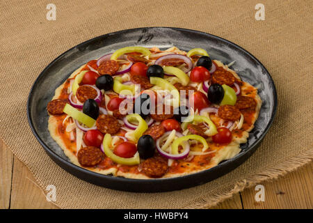 Rohe rustikale Pizza in Pfanne vor dem Backen Stockfoto