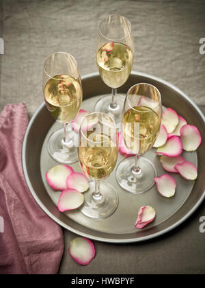 Glas Champagner und Rosen Blütenblätter Stockfoto