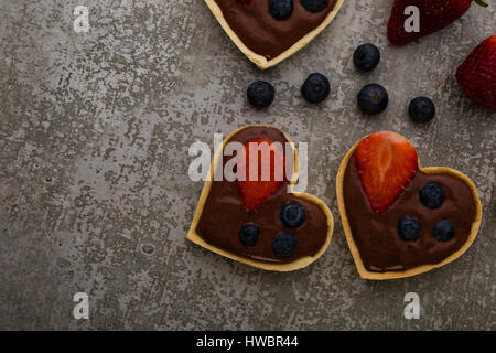 Herz Form Schokolade Torte mit Erdbeeren und Heidelbeeren Stockfoto