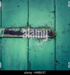 Grunge Rusty Scharnier auf einem rustikalen grünen Holztür Stockfoto