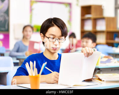 asiatische Grundschule Schüler mit Brille in der Klasse zu studieren. Stockfoto