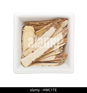 Traditionelle chinesische Medizin - Huang Qi (Astragalus Wurzel) in eine quadratische Schale isoliert auf weißem Hintergrund Stockfoto