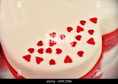 Süße Kuchen in Form von roten Rosen schmücken die Hochzeitstorte mit mehr dekorative Zweige der weiße Creme. Bei einer Hochzeit in Novi Sad, SERBI fotografiert. Stockfoto