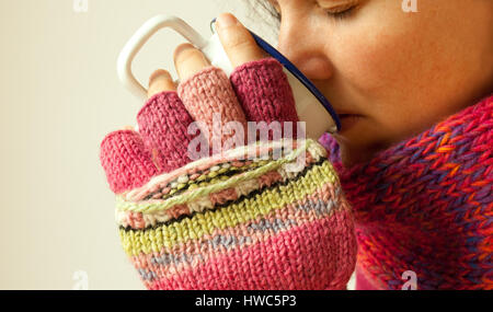 Eine Frau trinkt ein warmes Getränk im Winter Stockfoto