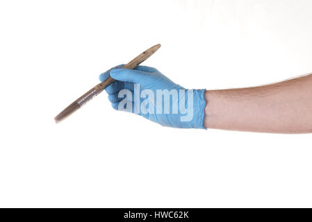 Stock Foto - Rechte Hand tragen einen blaue Nitril-Handschuh mit einem Pinsel, isoliert auf weiss Stockfoto