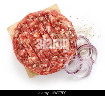 rohes Hackfleisch mit Zwiebeln, Pfeffer und Salz zur Herstellung eines Burger isoliert auf weißem Hintergrund, Ansicht von oben Stockfoto