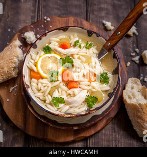 Schüssel mit italienischer Zitrone Orzo Hühnersuppe Stockfoto