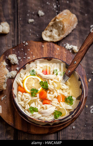 Schüssel mit italienischer Zitrone Orzo Hühnersuppe Stockfoto