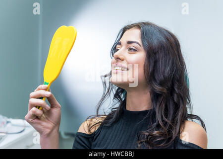 In Spiegel lächelnde Frau. Stockfoto