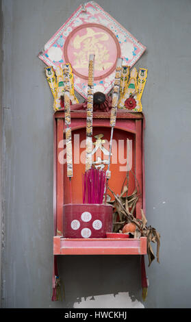 Kleiner Schrein oder Altar mit Weihrauch auf Haus Wand in Hong Kong Stockfoto