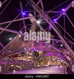 Quadratische Blick auf Menschen, jogging und walking über die Helix-Brücke in der Nacht in Singapur. Stockfoto