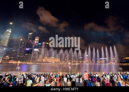 Horizontale Ansicht der Zuschauer an die Wunder voller Licht und Soundshow nachts in Singapur. Stockfoto