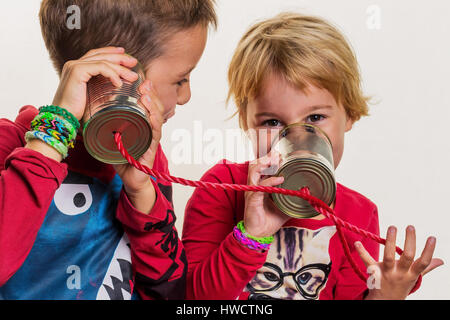 Zwei kleine Kinder rufen Sie ein Telefon aus zwei Dosen., Zwei Kleine Kinder Telefonieren Mit Einem Telefon aus Zwei Dosen. Stockfoto