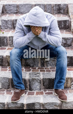 Ein Mann sitzt einsam auf Schritte, Ein Mann Sitzt Einsam Auf Stufen Stockfoto