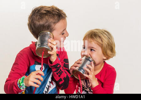 Zwei kleine Kinder rufen Sie ein Telefon aus zwei Dosen., Zwei Kleine Kinder Telefonieren Mit Einem Telefon aus Zwei Dosen. Stockfoto