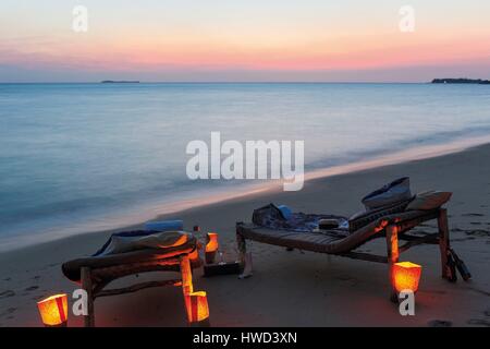 Tanzania, Zanzibar, Chapwani, Chapwani Private Island Resort, romantische Stühle am Strand bei Sonnenuntergang Stockfoto