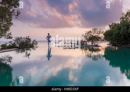 Tanzania, Zanzibar, Chapwani, Chapwani Private Island Resort, Spiegelbild der Tourist auf einen Infinity-Pool bei Sonnenaufgang Stockfoto