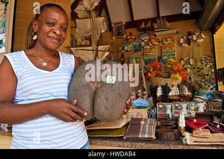 Seychellen, Mahe Island, Victoria, Norma Rosette mit einem endemischen Coco de Mer Mutter (Lodoicea maldivica) in den Armen vor ihr Shop auf Francis Rachel Street Stockfoto