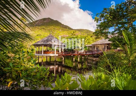 Seychellen, Silhouette Island, Hilton Seychelles Labriz Resort & Spa Teppanyaki Restaurant bei Sonnenaufgang, ein Graureiher (Ardea cinerea), der sich auf dem Dach thront Stockfoto