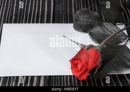 Rose und Hinweis auf dem Holztisch Stockfoto