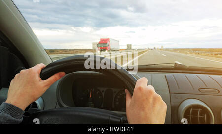 Weibliche Hände auf Auto Lenkrad fahren Fahrzeug auf zwei-spurige Autobahn, Treiber pov Stockfoto