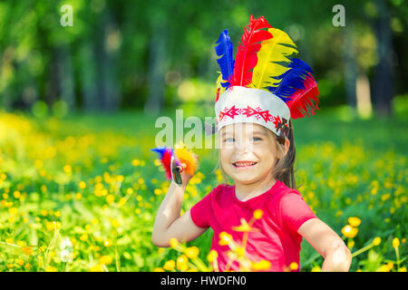 kleine lustige Mädchen spielen Indianer Stockfoto