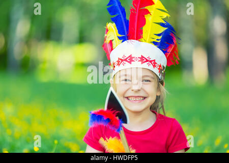 kleine lustige Mädchen spielen Indianer Stockfoto