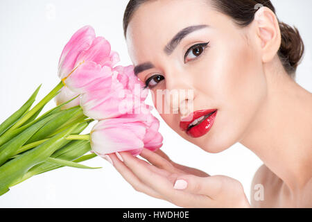 Portrait der schönen Frau berühren Knospen rosa Tulpen Stockfoto