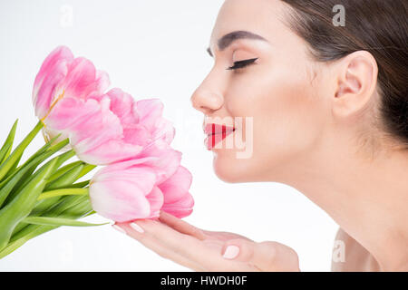 Portrait der schönen Frau Knospen rosa Tulpen mit geschlossenen Augen zu berühren Stockfoto