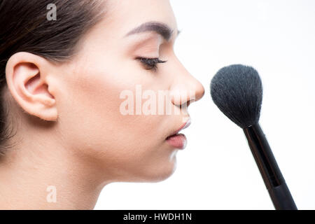 Seitenansicht der schönen Frau Pulver Gesicht mit Pinsel isoliert auf weiss Stockfoto