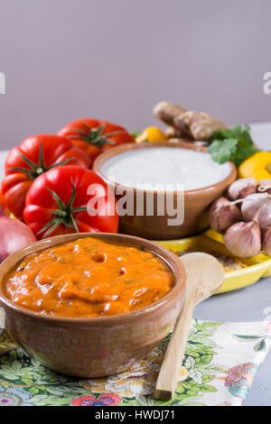 Schüssel mit pflanzlichen Tikka Masala Sauce und Zutaten, die eingehen, so dass es - rote Tomaten, Paprika, Karotten, Koriander Blätter, Zwiebel, Knoblauch, Juwel Stockfoto